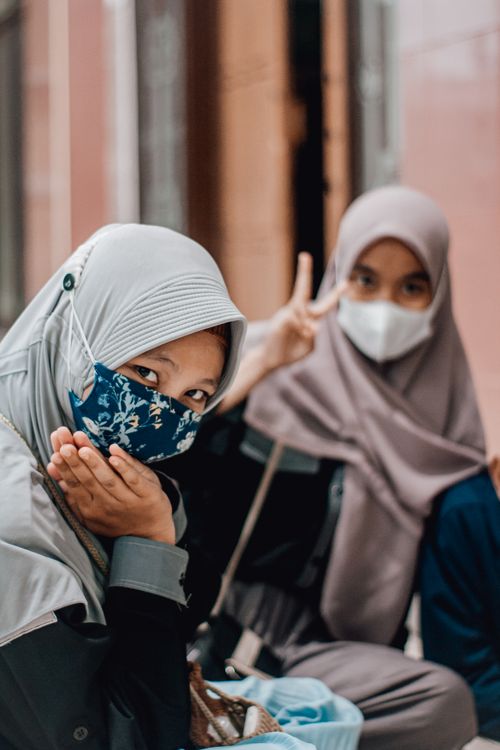 Free Two Muslim women in hijabs and face masks pose together outdoors in Central Java, Indonesia. Stock Photo