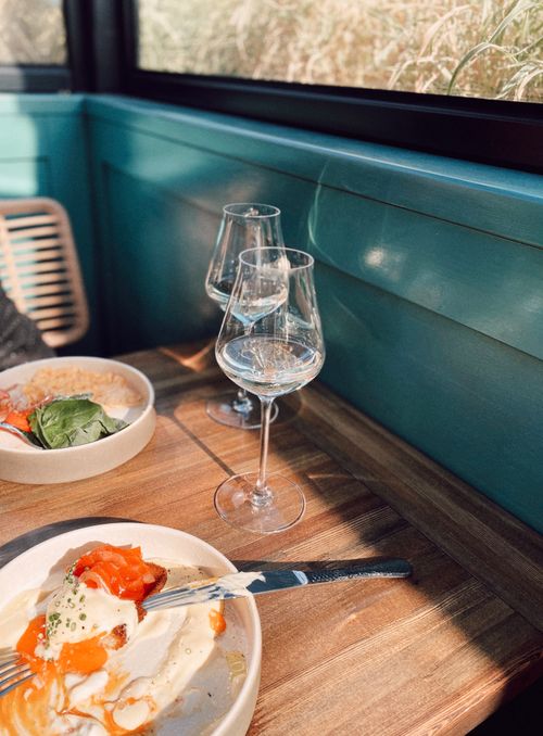 Free Inviting brunch scene with fresh food and wine glasses on a wooden table. Stock Photo