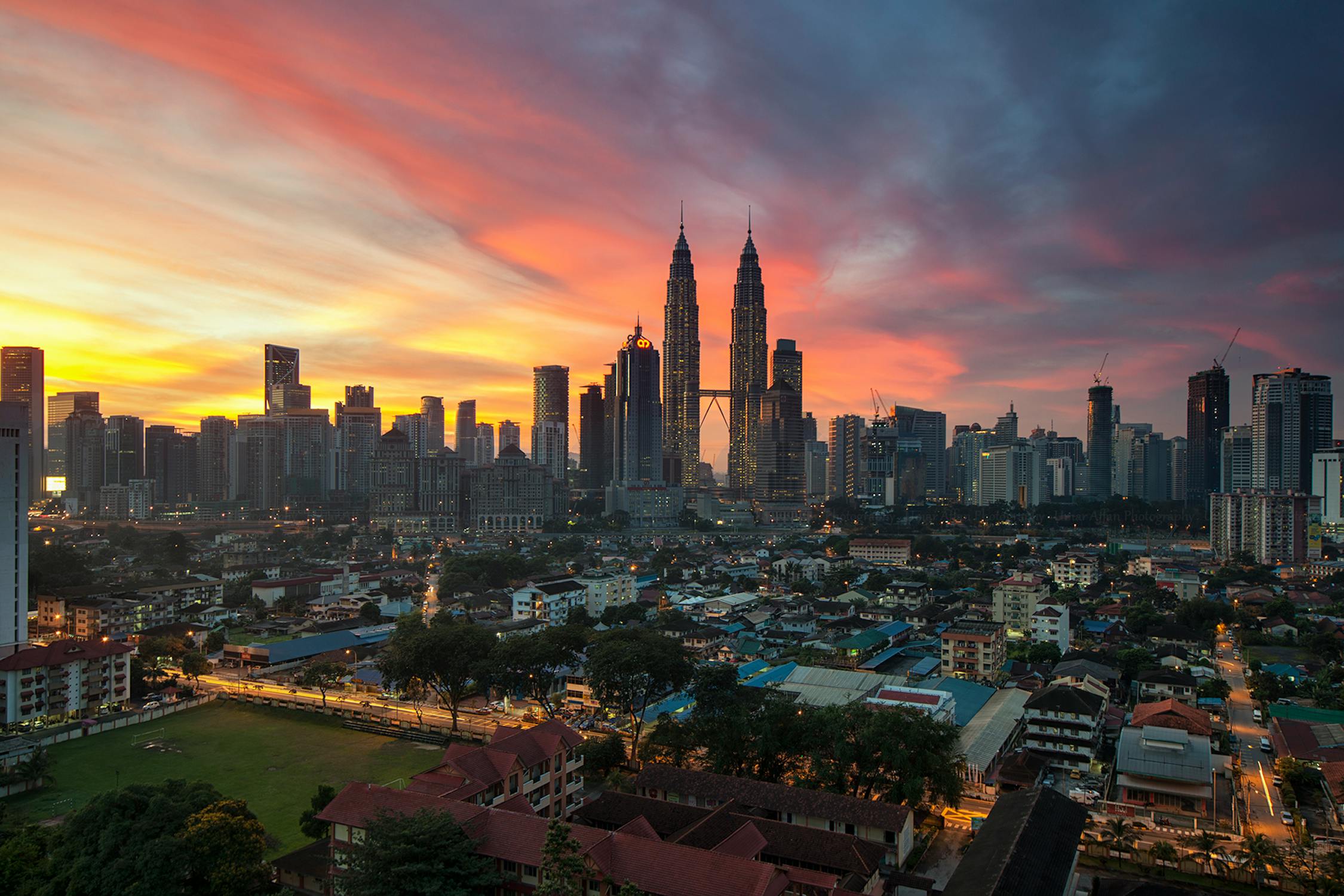 Stunning view of Malaysia's iconic Petronas Towers lit up at dusk, symbolizing the country's welcoming visa-free policy for Indian tourists and the exciting travel opportunities with Explorerg.