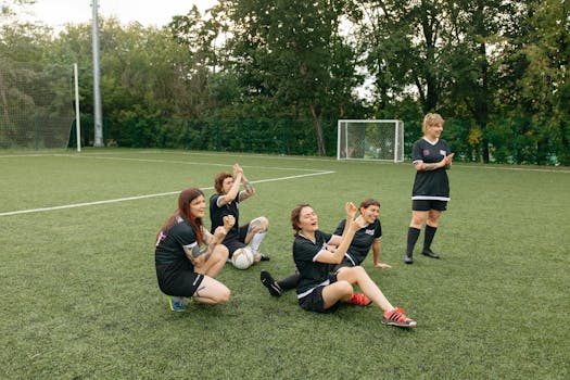 A women's soccer team celebrating joyfully on the field. Team spirit and sportsmanship.