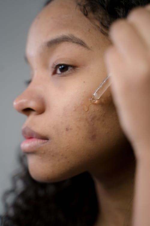 Good Molecules Discoloration Correcting Serum: Woman applying the face serum