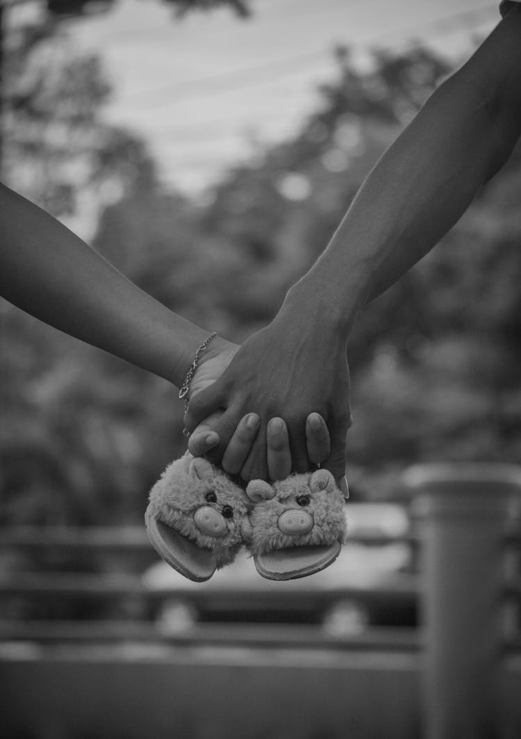 Couple Holding Baby Shoes In Hands