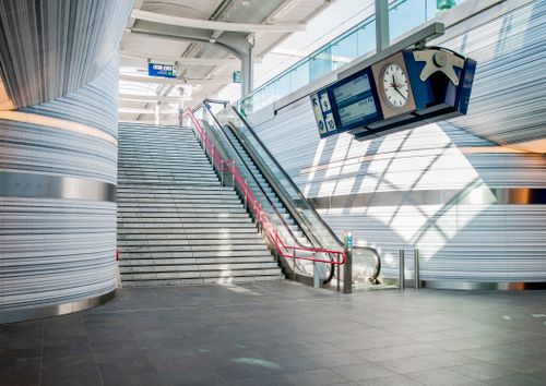 Free Spacious, contemporary train station interior in Zwolle with escalator and large clock. Stock Photo
