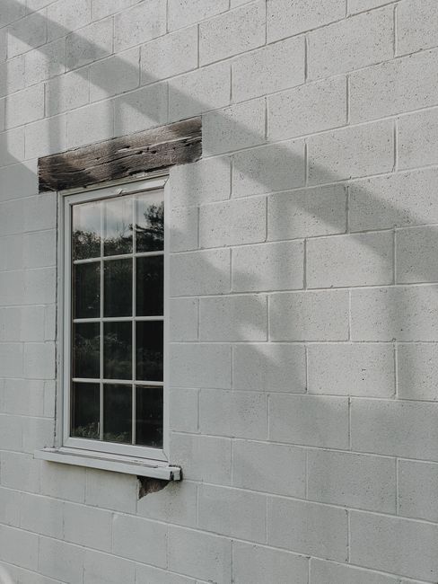 A white brick wall with a glass window and dramatic shadows at Port Severn.