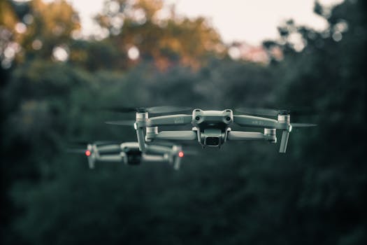 A close-up of drones flying above a forest in Itchingfield, England, showcasing advanced technology.