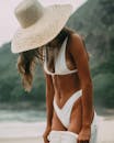 里约热内卢风景优美的海滩上穿着白色比基尼、戴着帽子的时尚女子