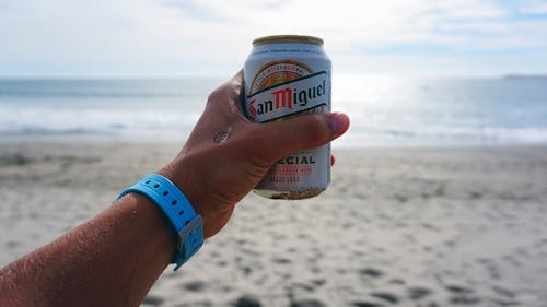 Free Person Holding San Miguel Beer Tin Can Stock Photo