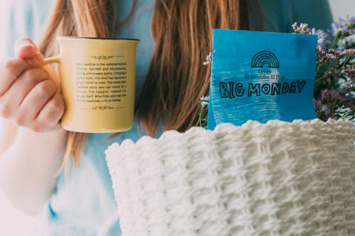 A Person in Blue Shirt Holding Yellow Cup