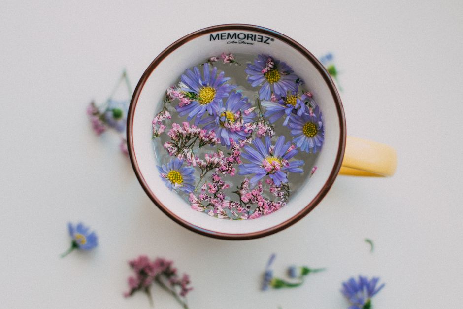 A top view of a cup with colorful flowers and water, perfect for a fresh and artistic display.