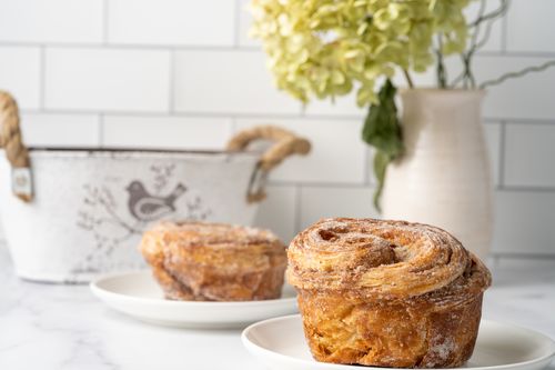 Free Delicious cinnamon croissant pastries on plates with a decorative background, ideal for food lovers. Stock Photo