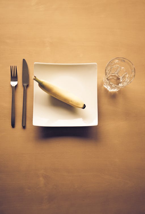 White Bread on White Ceramic Plate Beside Clear Drinking Glass