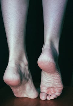 Detailed close-up showing the underside of bare feet against a dark background.
