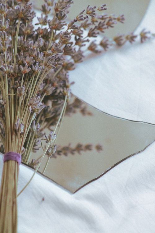 Free Elegant dried lavender bouquet on soft white linen with mirror reflection. Stock Photo