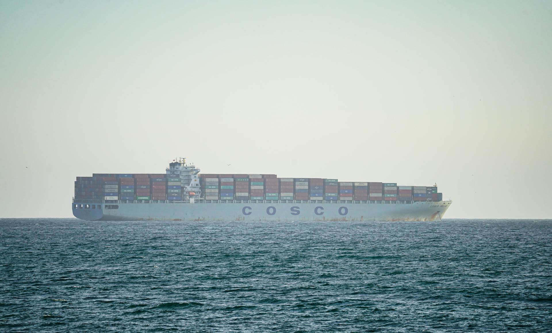 A cargo ship transporting containers across the Pacific Ocean near Long Beach, California.