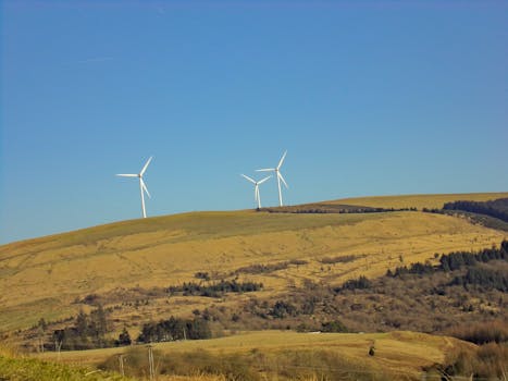 Scenic view of wind turbines on hills in Cymmer, Wales, showcasing renewable energy in a natural setting.