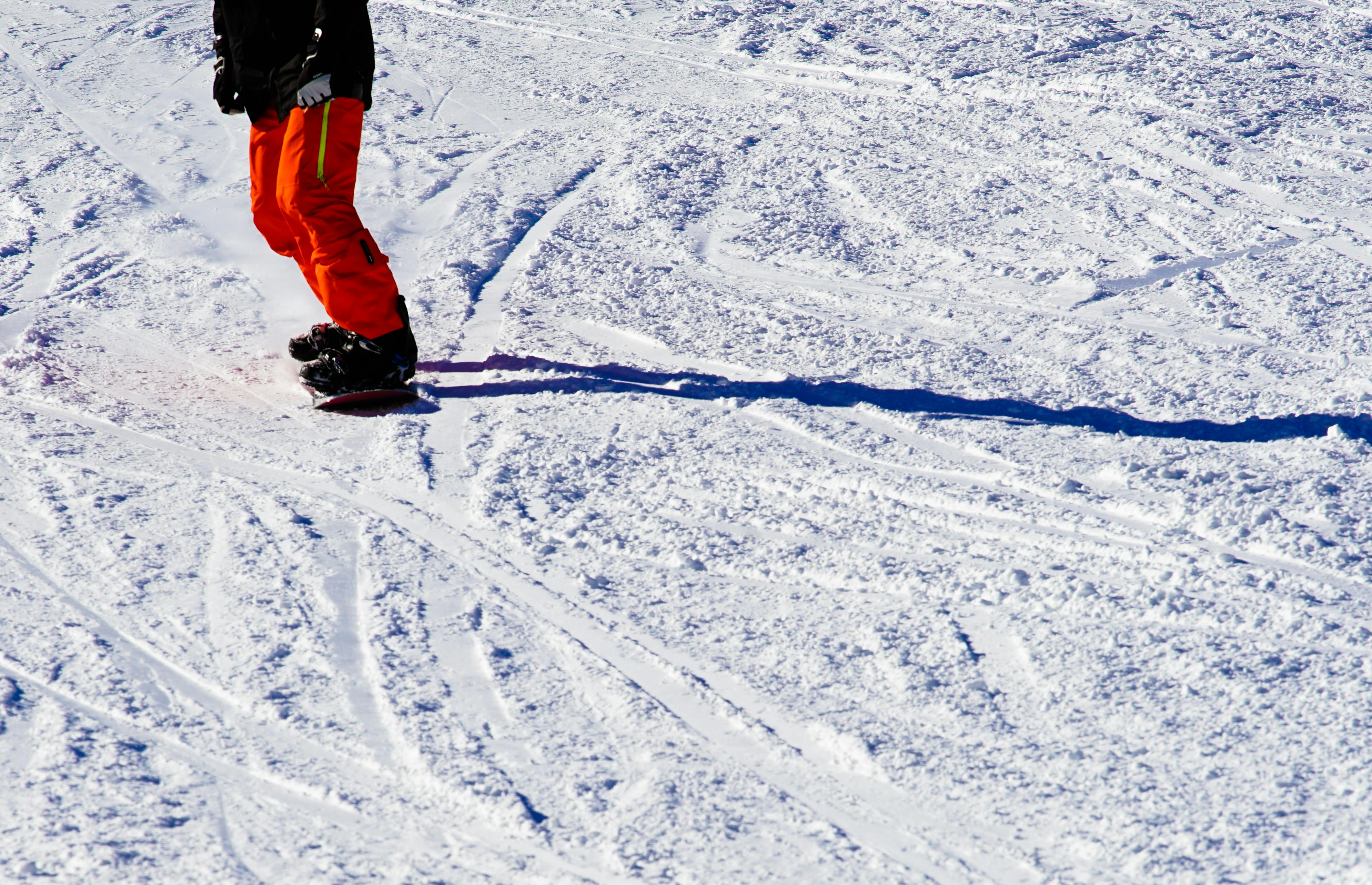 Prescription Goggle Inserts - A snowboarder enjoying a sunny day on a snowy slope in winter.