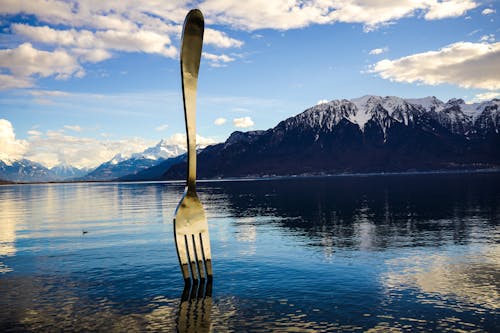 Free Gray Stainless Steel Fork on Water With Overlooking Mountain at Daytime Stock Photo