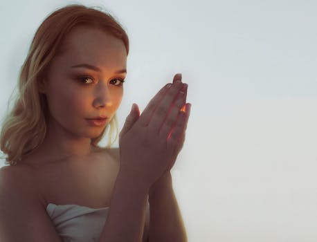 一位年轻女子的肖像中，她双手轻捧光芒，营造出神奇的氛围