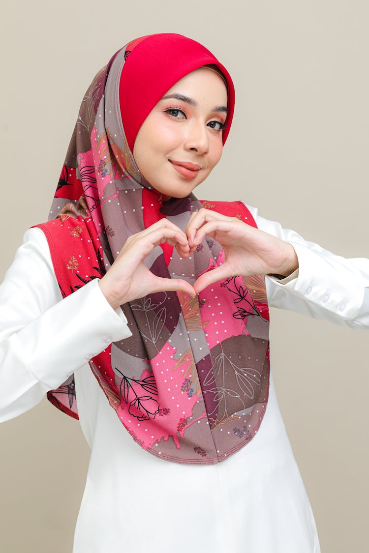 Woman In A Red Scarf Doing A Heart Shaped Hand Gesture