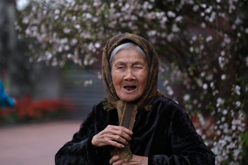 Close-Up Photo of an Elderly Woman Wearing a Brown Headscarf