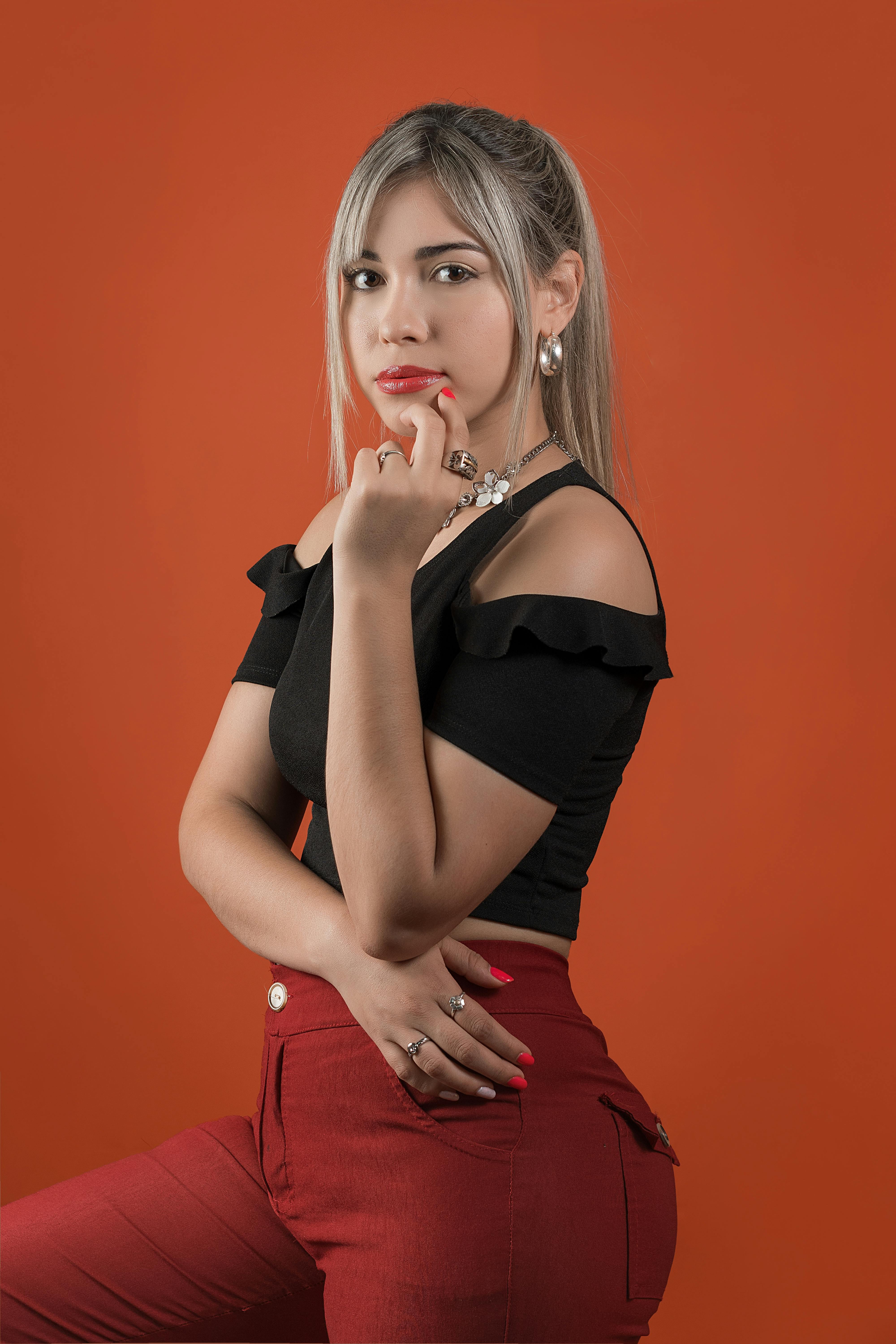 woman in a black top posing with her hand on her chin