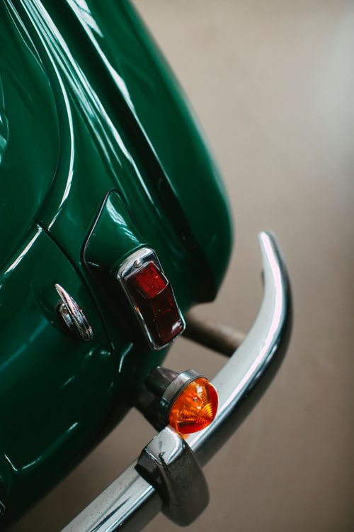 Free Close-up view of a vintage car's green tail light and bumper. Stock Photo