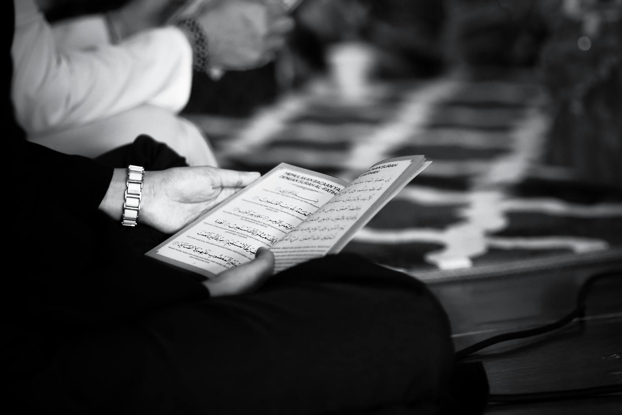 grayscale photography of a person holding book