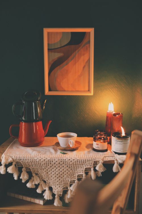 Free Warm and inviting console tabletop with candles, a teapot, and a cup of tea, ideal for cozy moments. Stock Photo