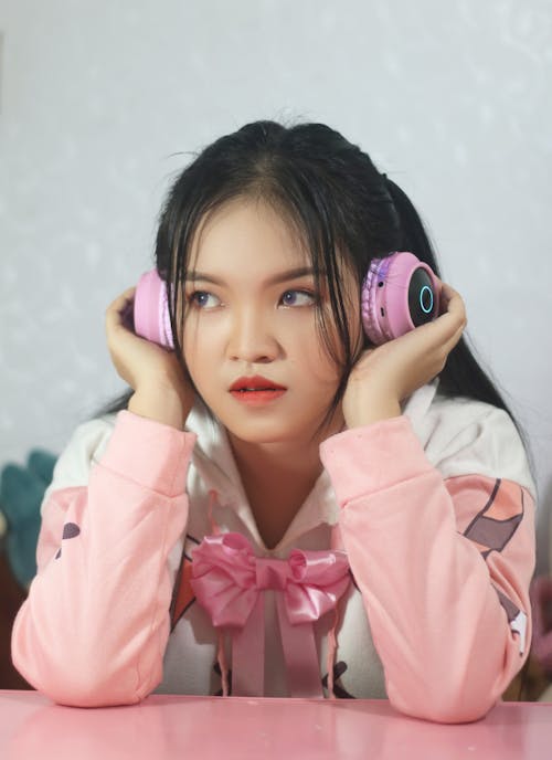 A Young Woman Wearing Pink Headphones