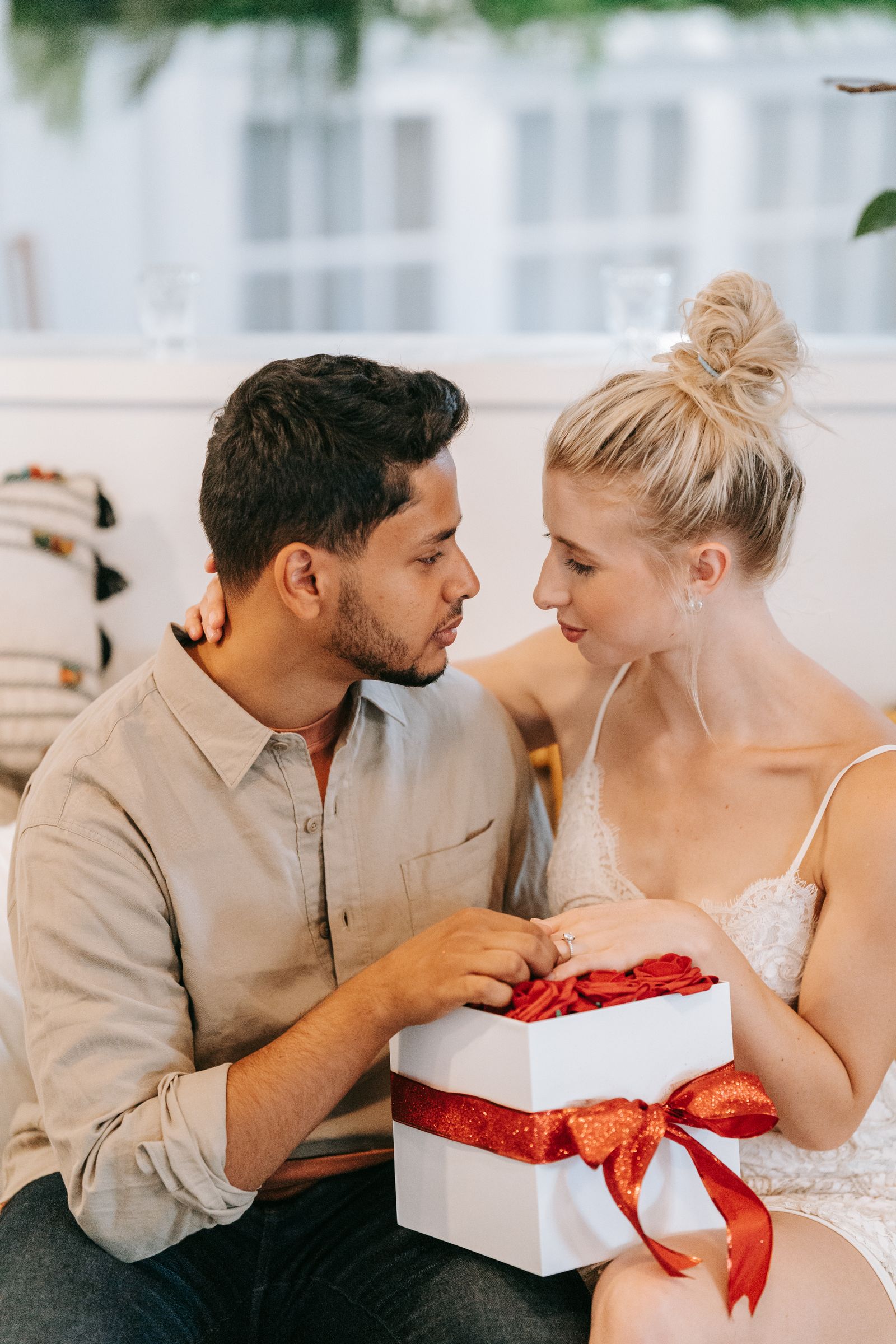 Two people sharing a gift while sitting together indoors