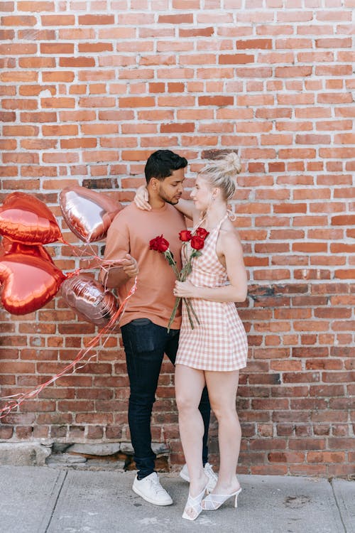 Man and Woman Holding Red Heart Balloons