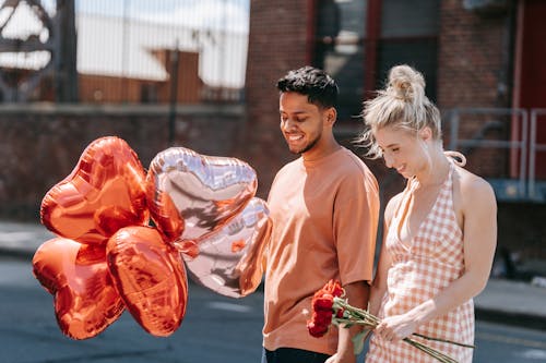 A Boyfriend Holding Heart Shaped Balloons for His Girlfriend