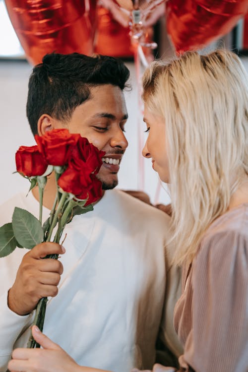 Free Couple Holding Roses While Facing Each Other Stock Photo