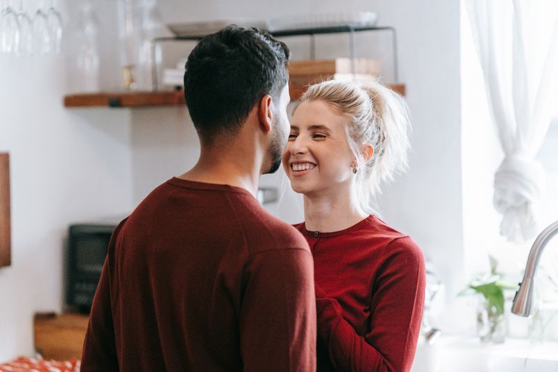 Cheerful couple enjoying a romantic moment in a cozy kitchen setting.