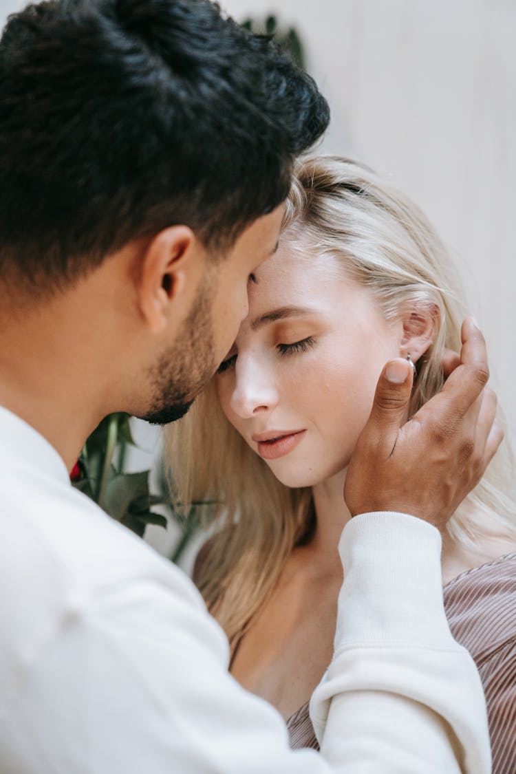 A Man Tucking A Woman's Hair Behind Her Ear