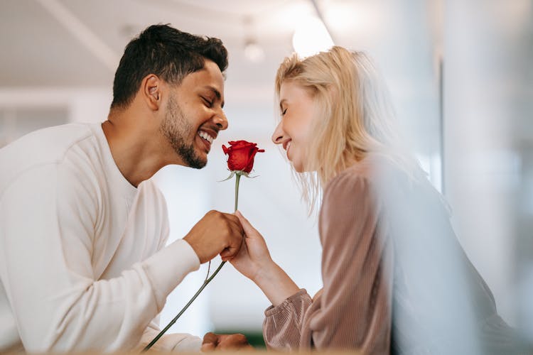 Man And Woman Holding A Rose