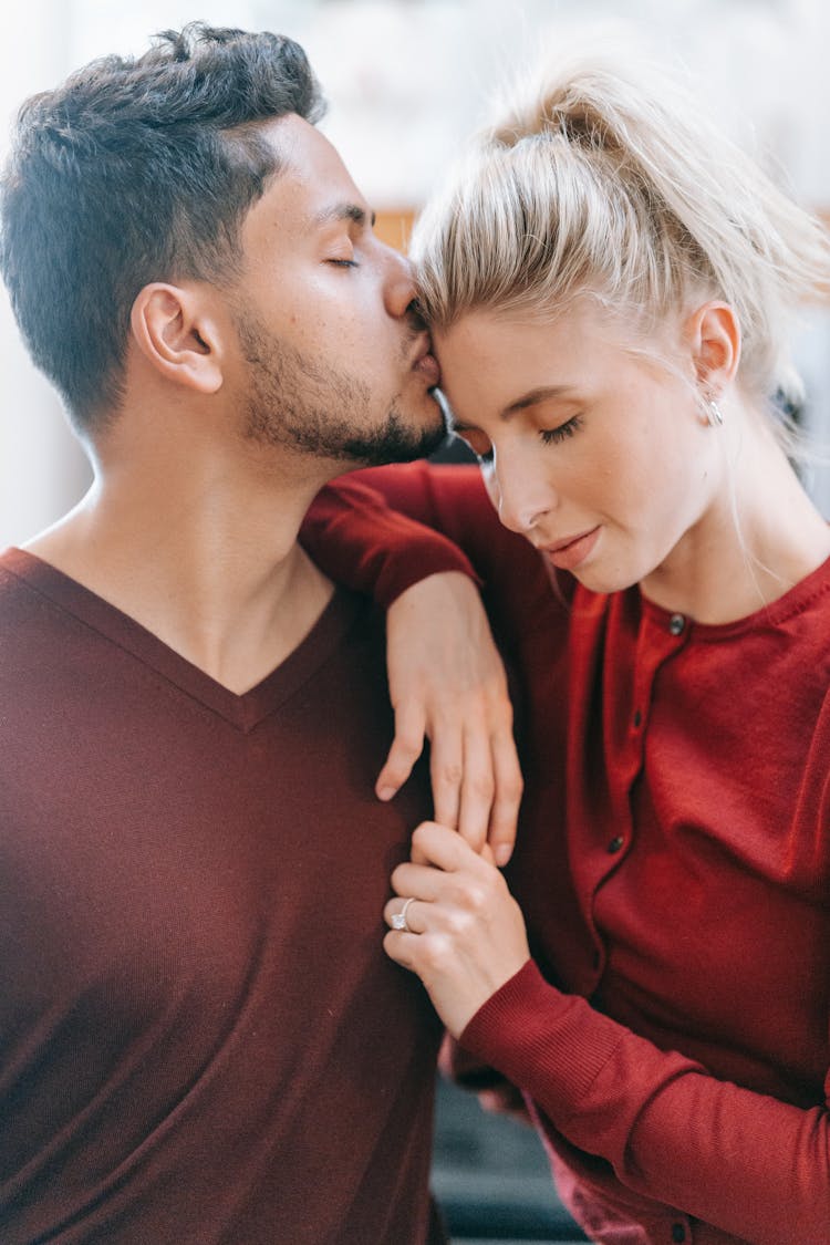 Man Kissing A Woman On Forehead