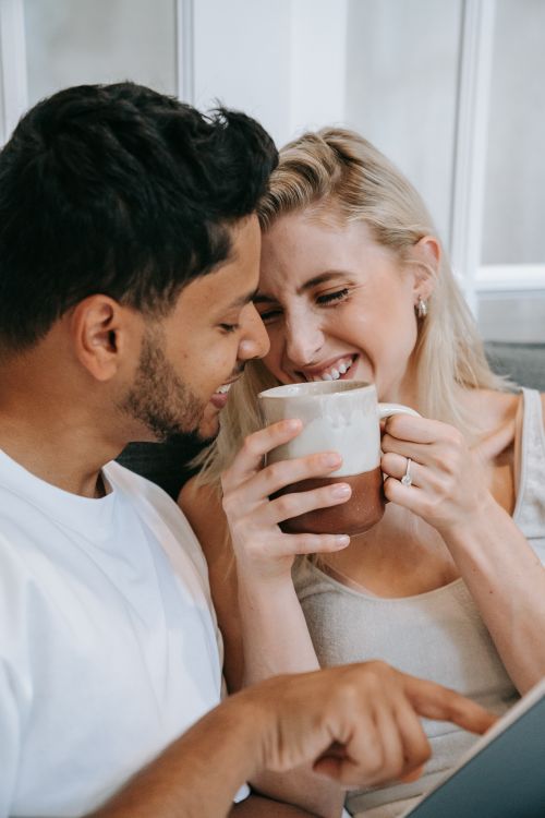 Free Happy couple sharing a warm moment with coffee indoors, smiling and close. Stock Photo