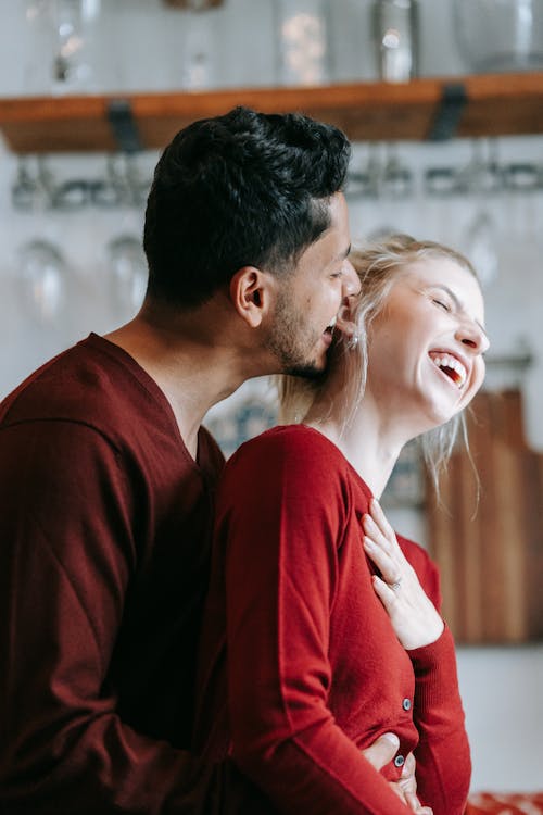 Free Man in Red Long Sleeve Shirt Kissing Woman in White Shirt Stock Photo