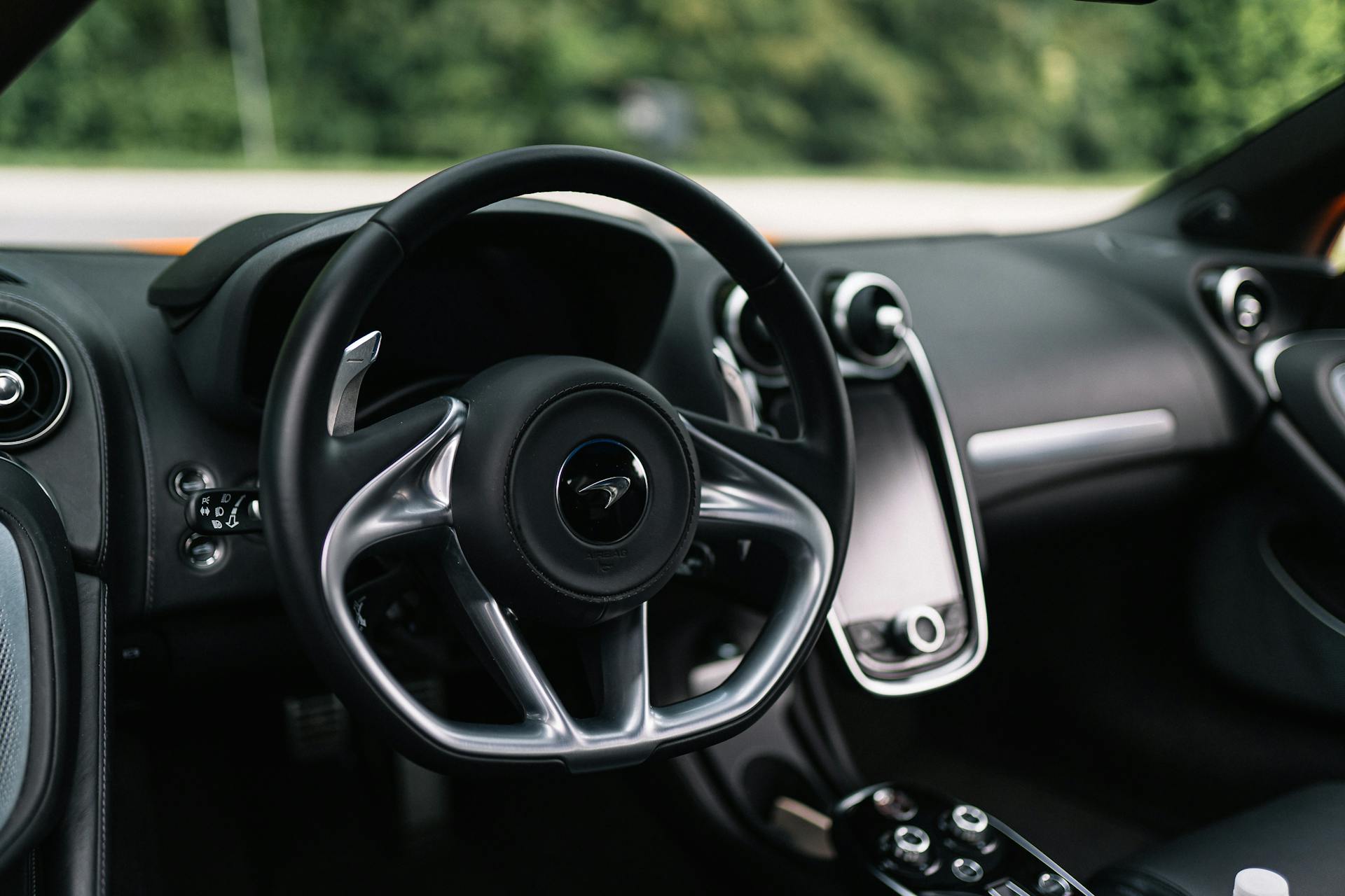 Close-up of a luxury sports car interior showcasing a sleek steering wheel design.