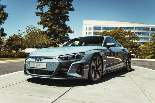 Free A luxurious Audi e-tron GT electric car parked in a modern urban area under clear skies. Stock Photo