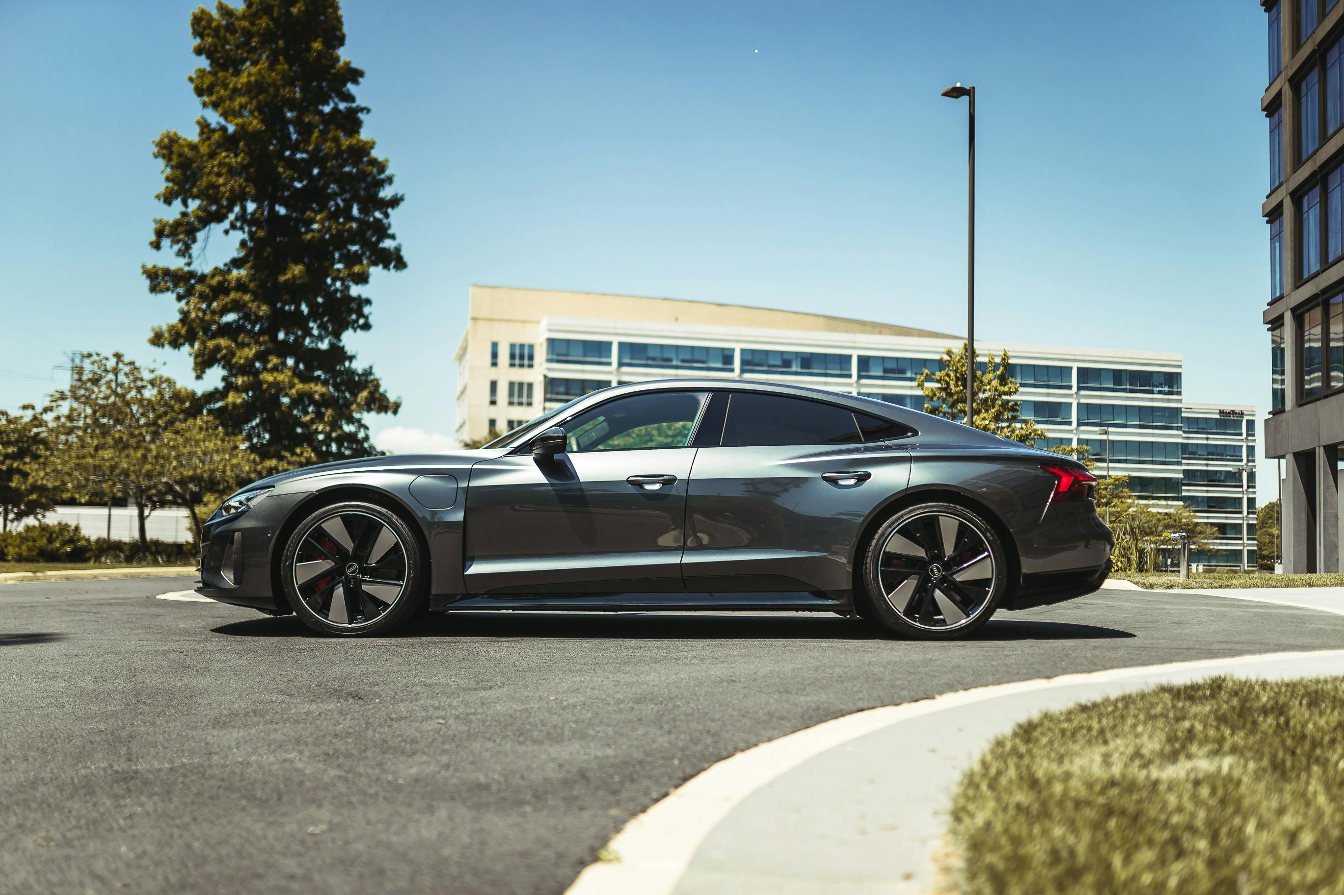 Free Side view of a sleek luxury car parked outdoors in a modern urban setting. Stock Photo