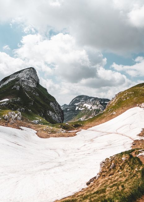 Stunning winter landscape of snow-covered peaks in Žabljak, Montenegro, under cloudy skies.