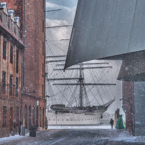 Free Captivating view of a historic sailing ship in Stralsund during a winter snowstorm, showcasing urban architecture. Stock Photo