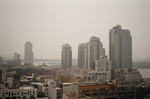 A hazy view of a bustling city skyline with a prominent bridge.