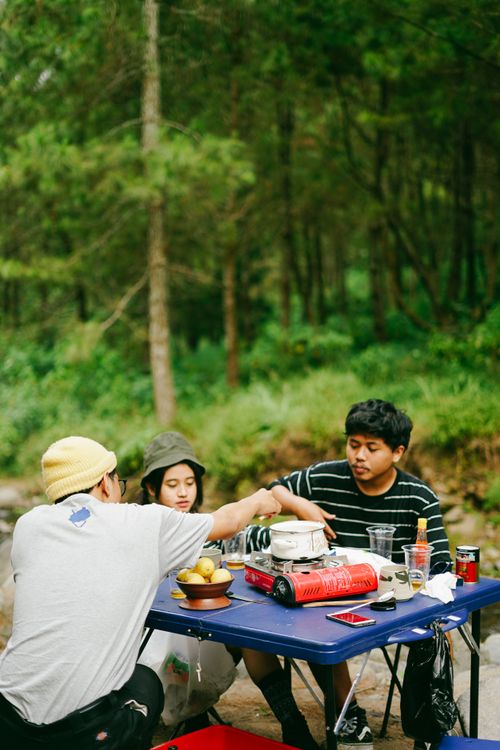 Free Group of teenagers enjoying a picnic in a scenic outdoor park setting during the day. Stock Photo