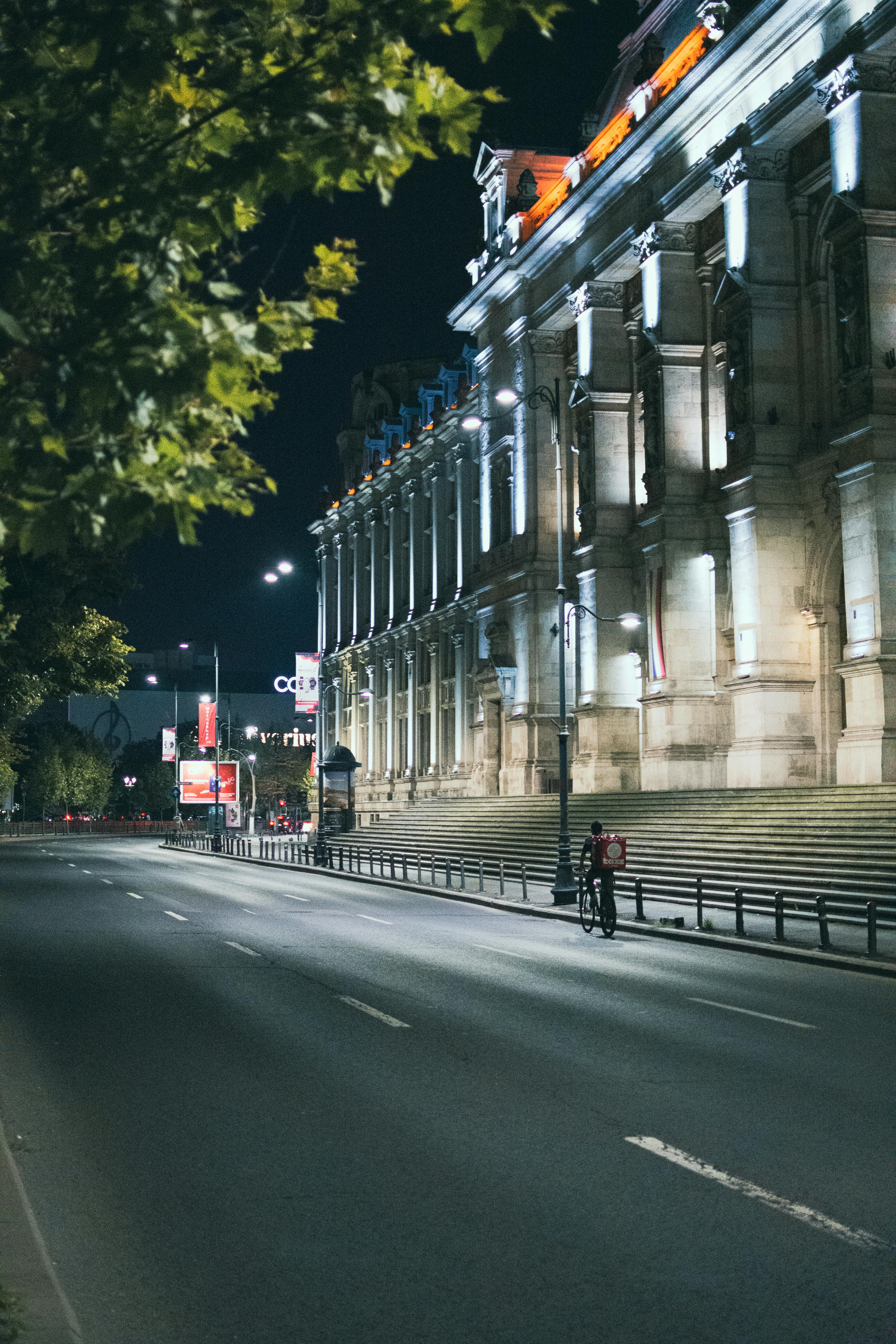 Fațada iluminată a unei clădiri din București, evidențiind frumusețea arhitecturală a orașului