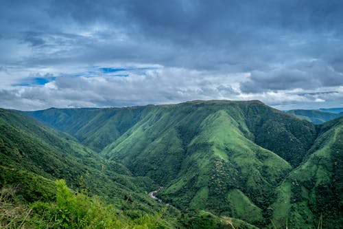 Пейзажная фотография зеленых гор под пасмурным небом