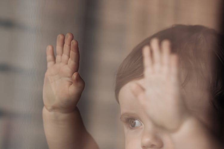 Close Up Of An Infant Touching Glass