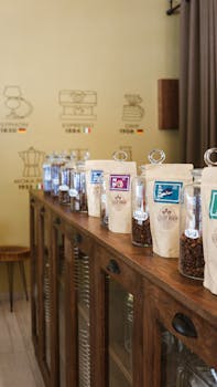 Coffee beans and packages neatly arranged on a wooden counter in a modern café.
